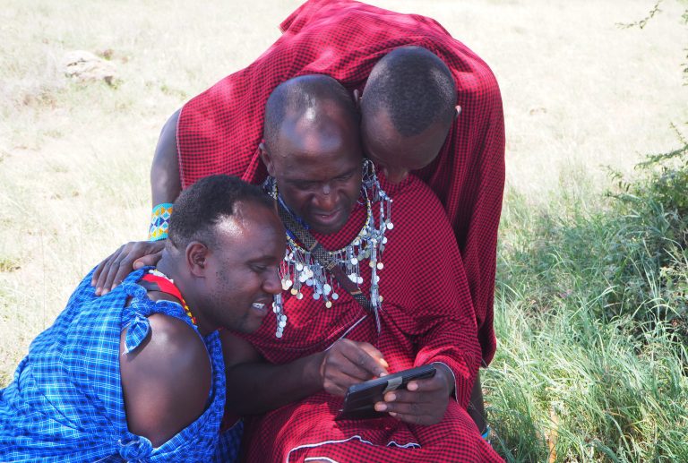 John with his Massai friends looking at a phone